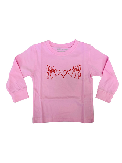 Pink long-sleeve shirt with red bow and heart design